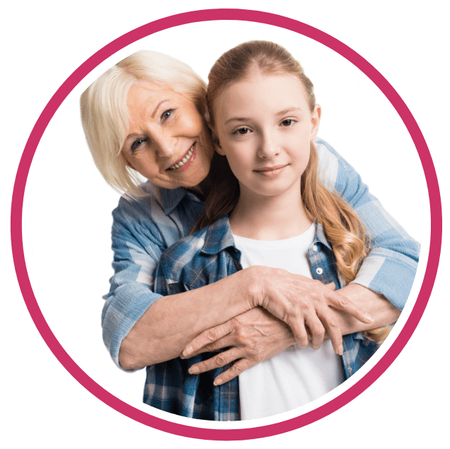 An older woman with short white hair hugs a young girl with long blonde hair from behind. Both are smiling in blue plaid shirts, standing against a white background within a pink circle—celebrating Vytala clinical nutrition for EPI support.