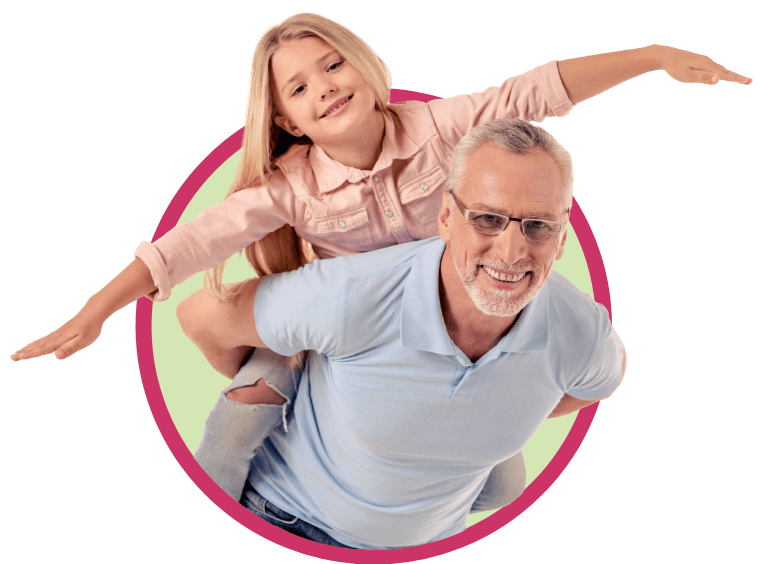 A smiling older man gives a piggyback ride to a happy young girl with long blonde hair, both with arms outstretched, inside a green circle with a pink border—capturing the joy that Seracal medical food brings to fat malabsorption treatment.